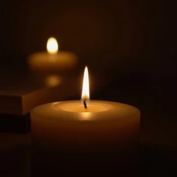Image of A soft-focus image of a single candle flame glowing in a cozy room, creating a calming, warm atmosphere that promotes relaxation and emotional balance.