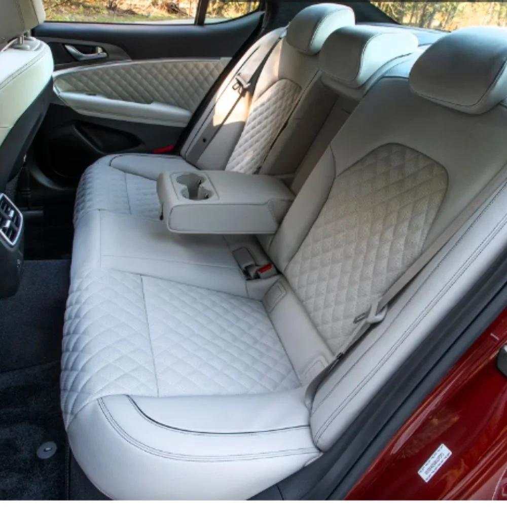 Rear seating area of the Genesis G70 showcasing ample legroom and premium upholstery for passenger comfort.