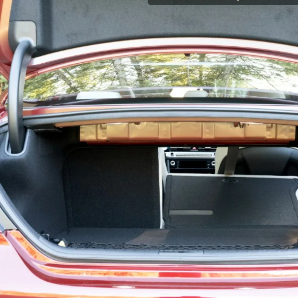 Open trunk of the Genesis G70 highlighting its spacious cargo area for luggage and storage.