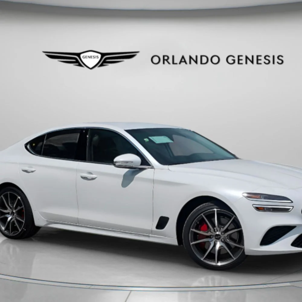 Cabin view of the Genesis G70 2.5T Standard trim featuring a leather-wrapped steering wheel, digital display, and modern dashboard layout.