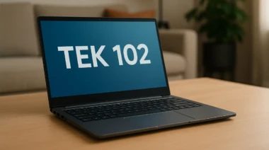 A sleek Tek 102 laptop on a wooden desk in a modern living room.